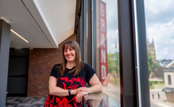 Lyndee Hansen stands in the Drewlo Lounge, a view of downtown visible out the large Richmond Street windows.