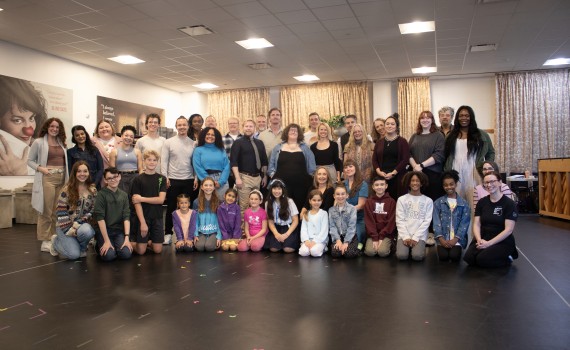 The cast and creative team of the Grand Theatre's 2024 production of The Sound of Music pose together for a group photo in the rehearsal hall.