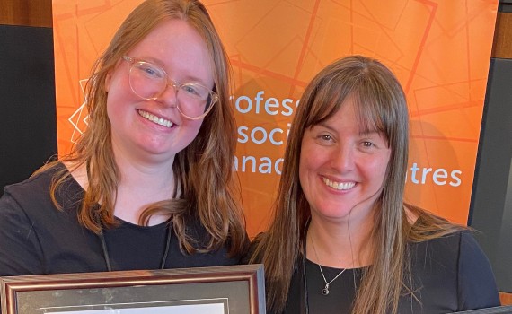Christine Gruenbauer and Lyndee Hansen post for a photo with awards at PACT Con.
